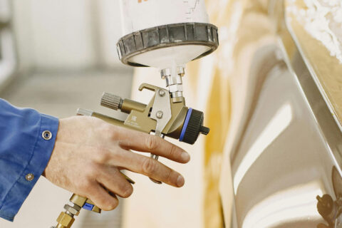 Technician painting automobile