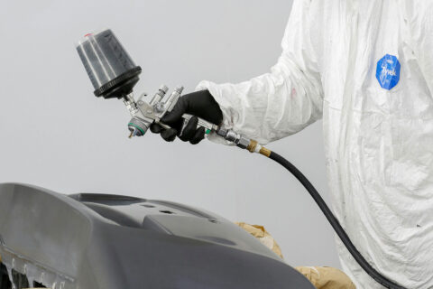 Technician painting part for collision repair